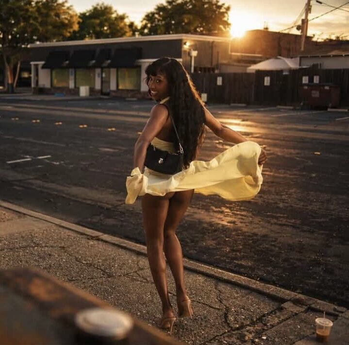 Simone Elise smiling in a white dress at sunset
