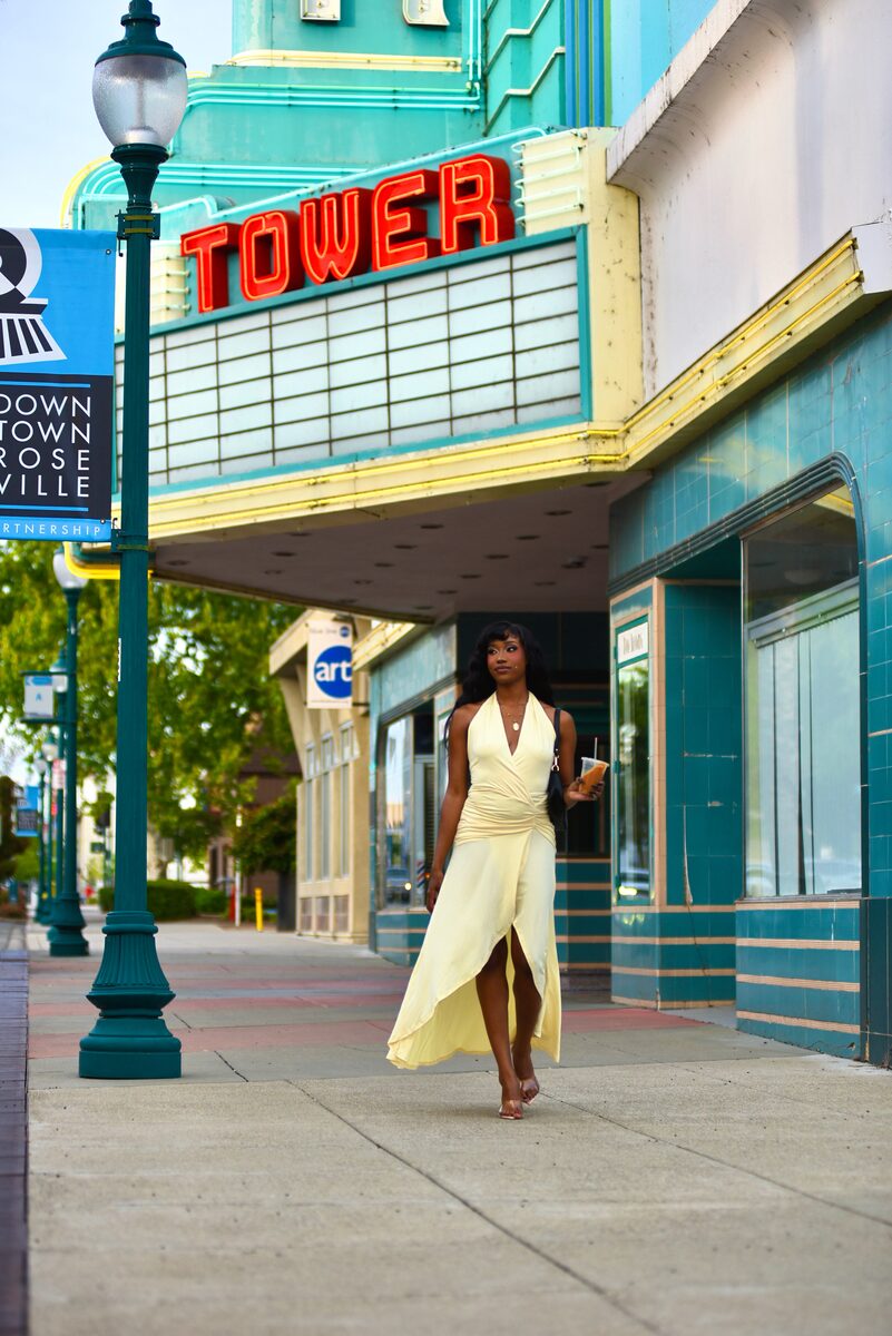 Simone Elise walking in front of the Tower Theatre in a white dress